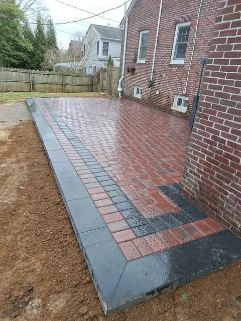 Red paver patio with a charcoal border